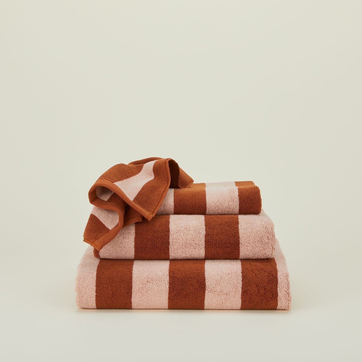 A stack of striped olive and sage terry towels in various sizes.