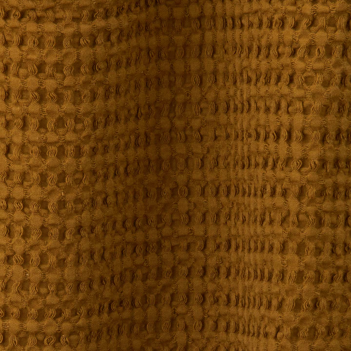 Close up view of simple waffle shower curtain in bronze