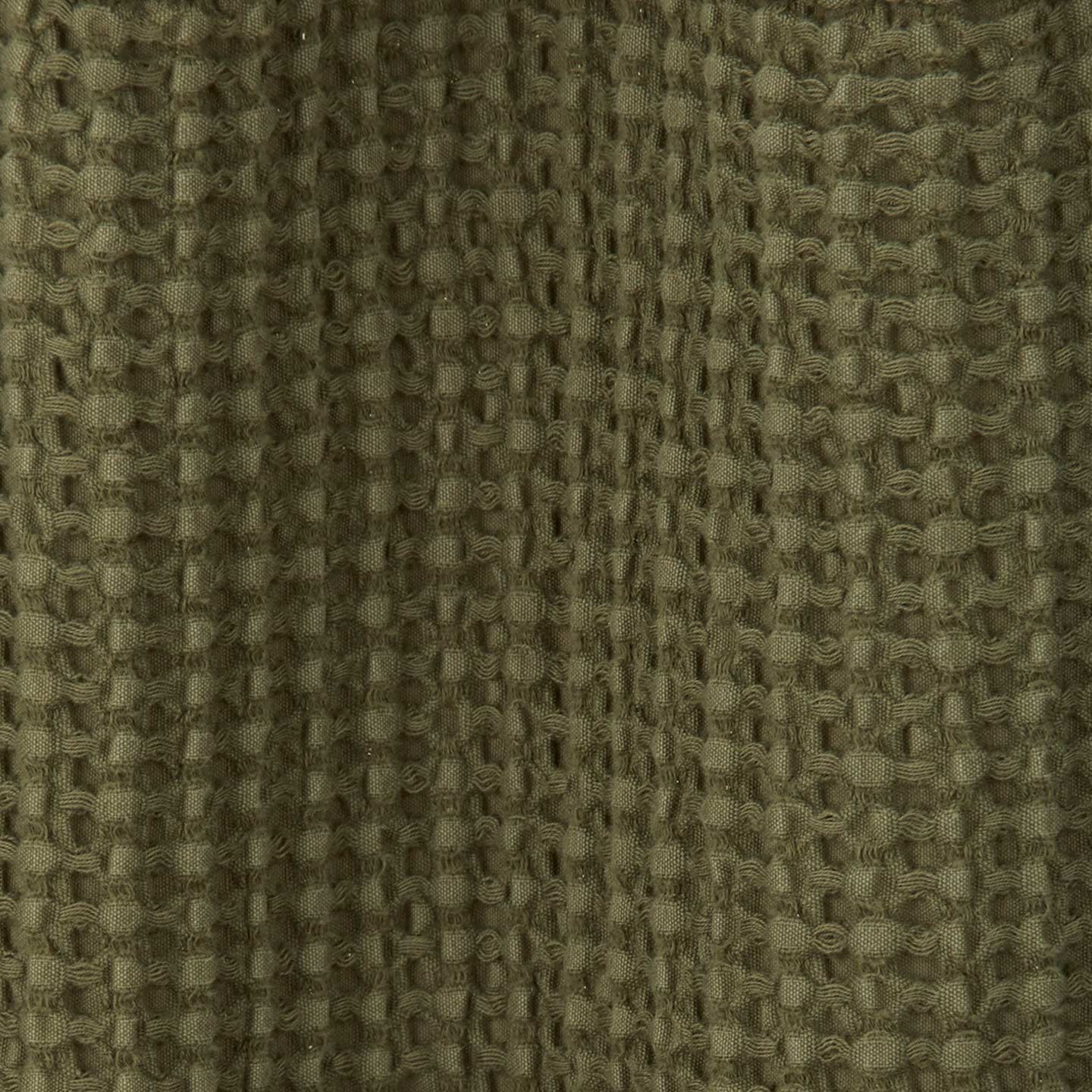 Close up view of simple waffle shower curtain in olive