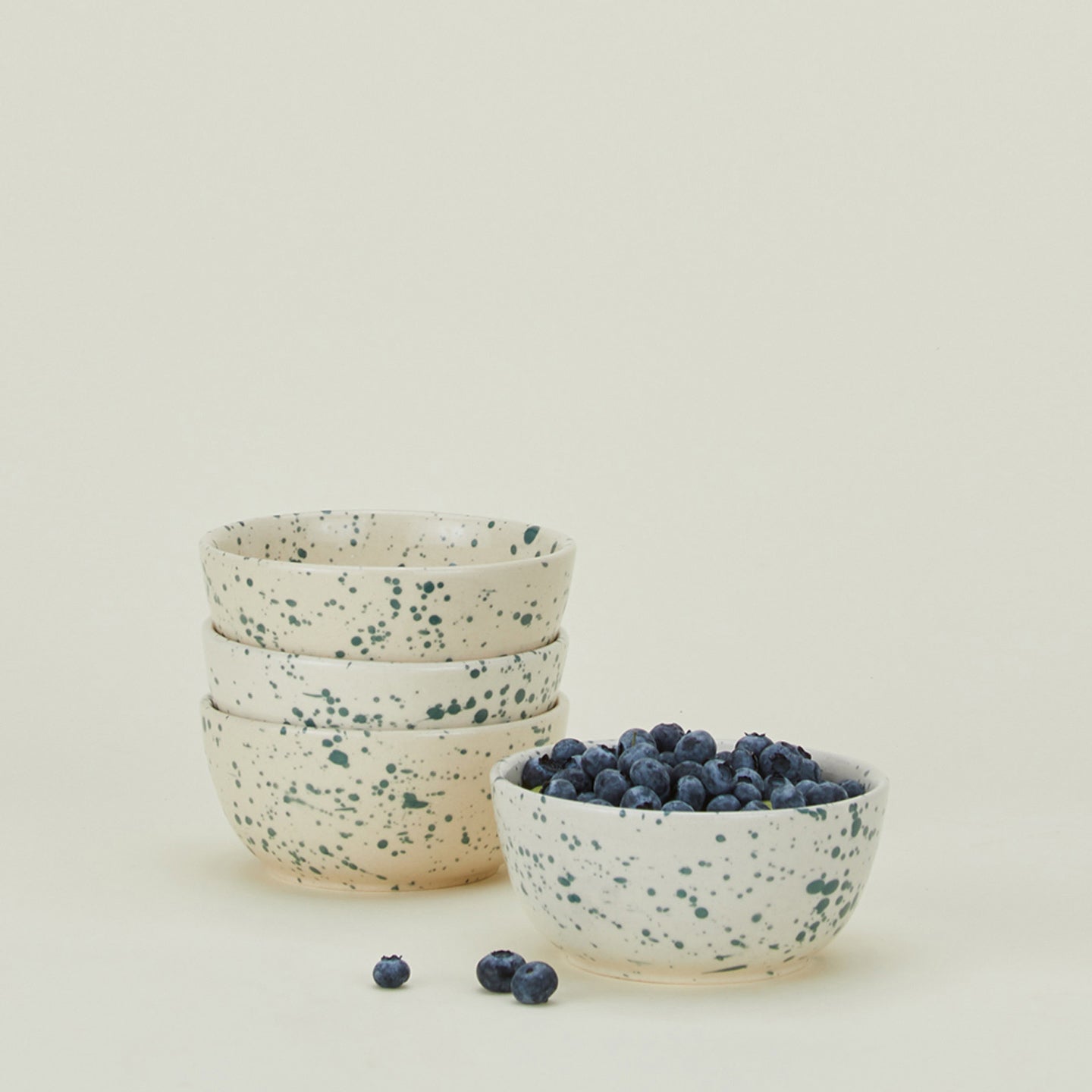 Set of four Splatterware bowls in Nettle with blueberries.