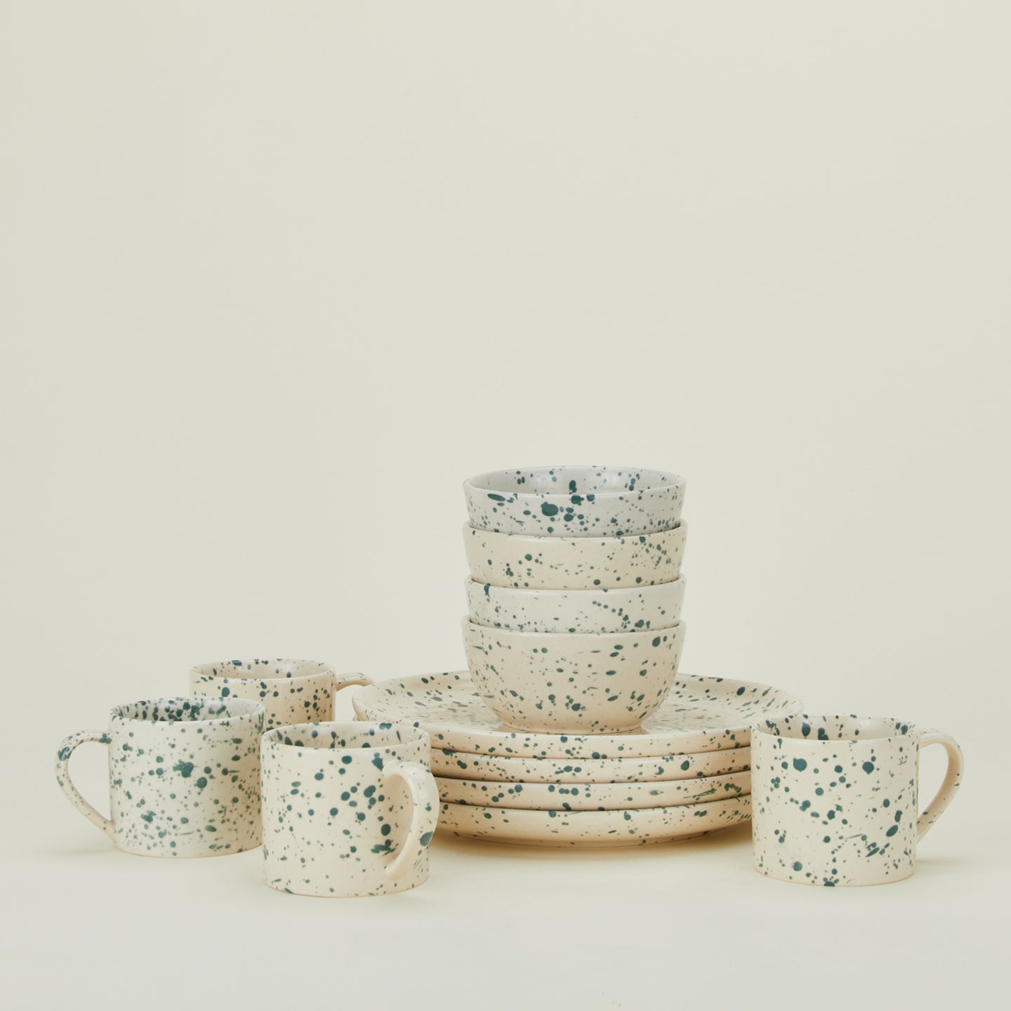 Set of four Splatterware plates, bowls, and mugs in Nettle.