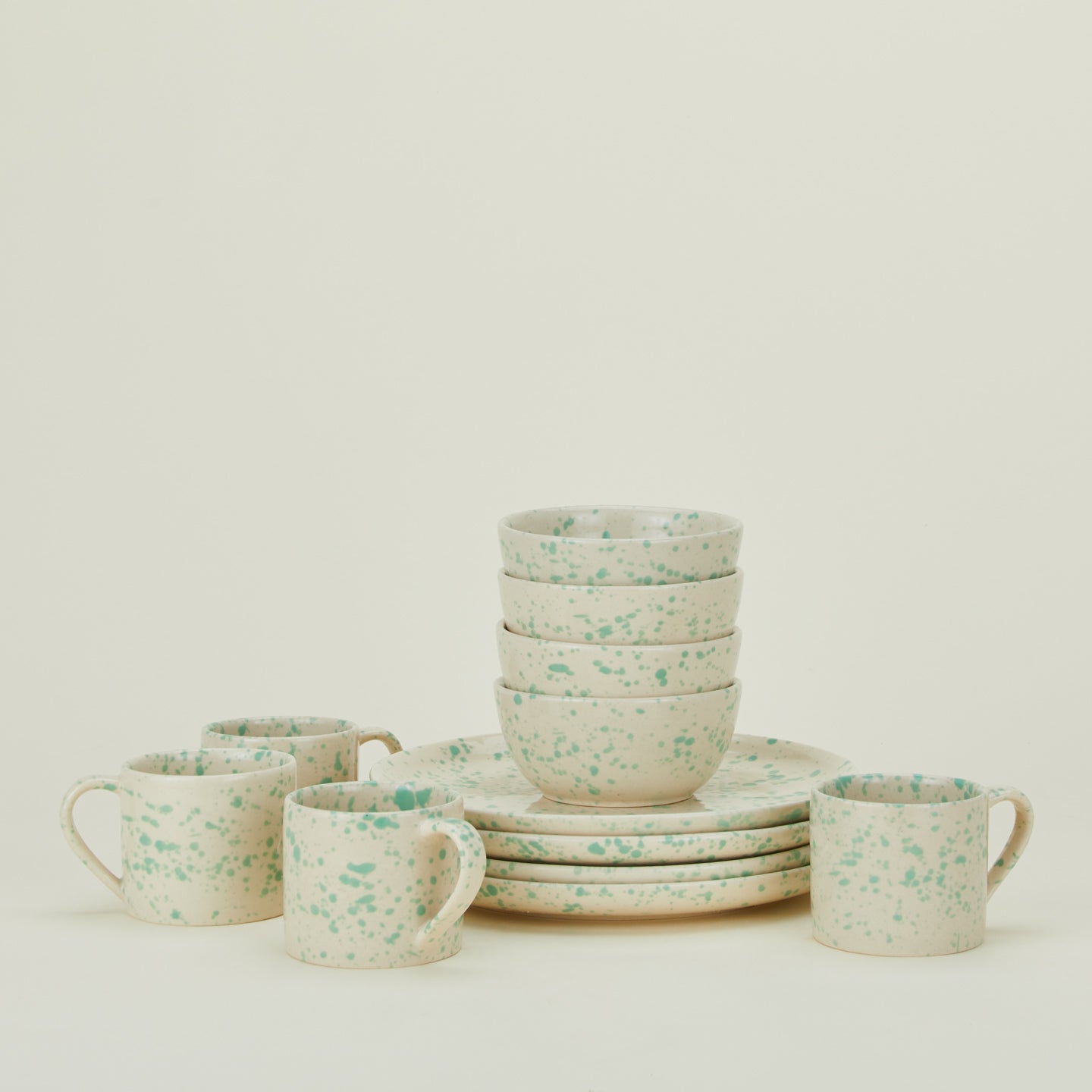 Set of four Splatterware plates, bowls, and mugs in Pool.