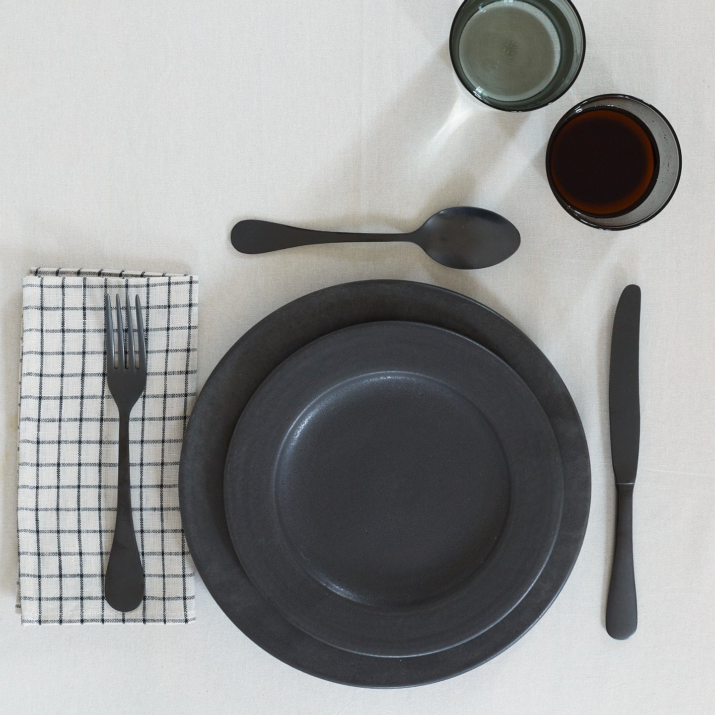 Placesetting with Stoneware Dinnerware pieces on ivory tablecloth.