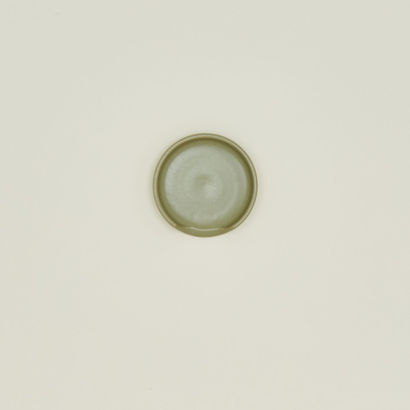 An overhead of an olive stoneware spoon rest.