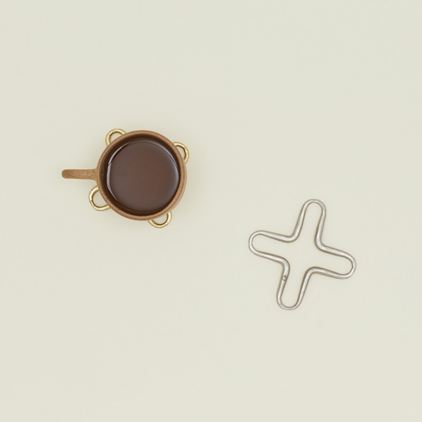 The collective forged mini trivet set in pewter and brass with cup of coffee