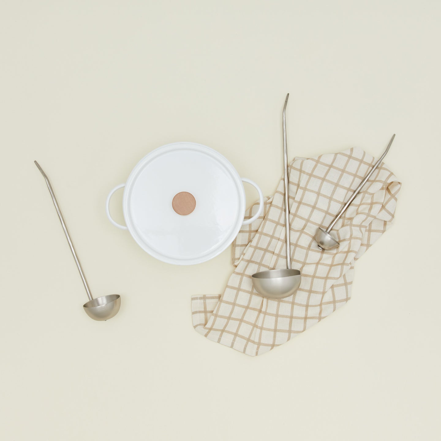 The collective forged pewter ladle set of three with dutch oven and checked kitchen towel