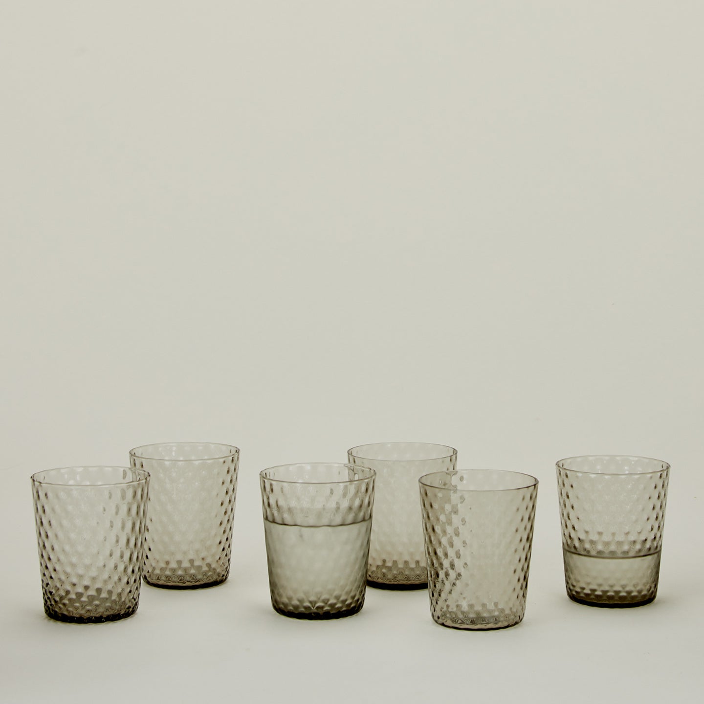 Set of 6 Veneziano Tumblers in Grey, with water.