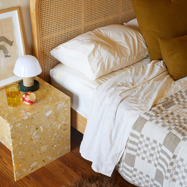 Cozy bed with simple plaid blanket.