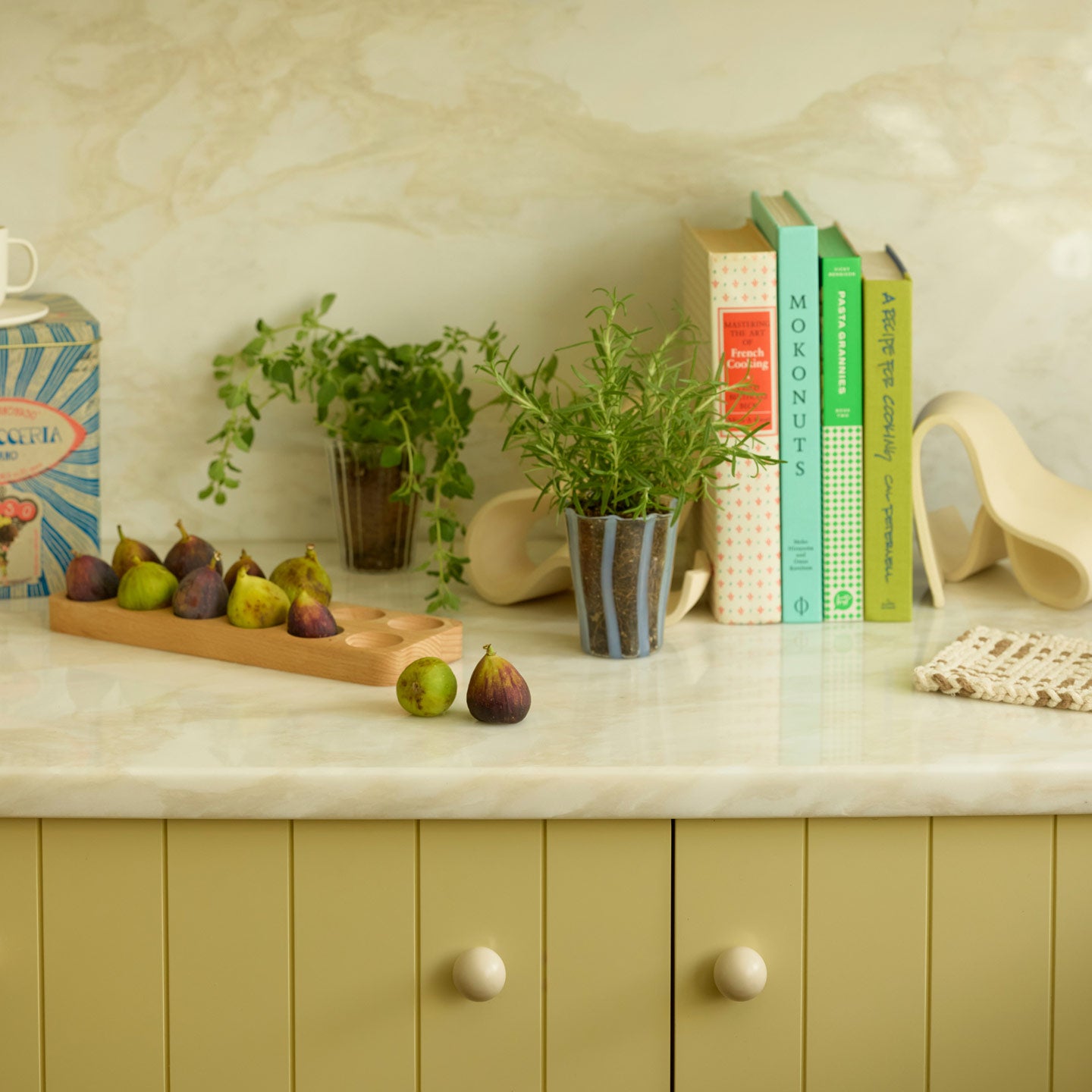 Kitchen setting with figs, plant, and cookbooks