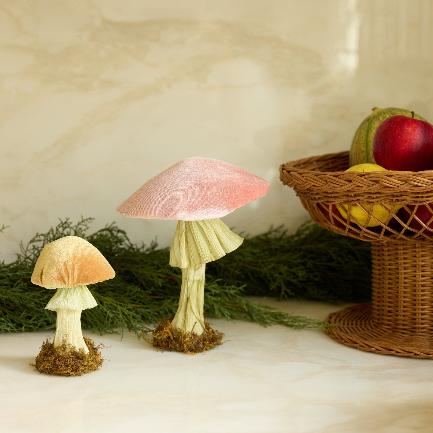 Velvet mushrooms on table with garland and footed bowl with fruit on table