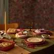 Tablescape with olive runner, place settings, flatware, glassware, and taper candle.