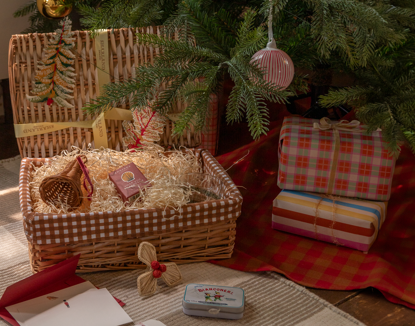 Wicker basket with decorative items under a Christmas tree