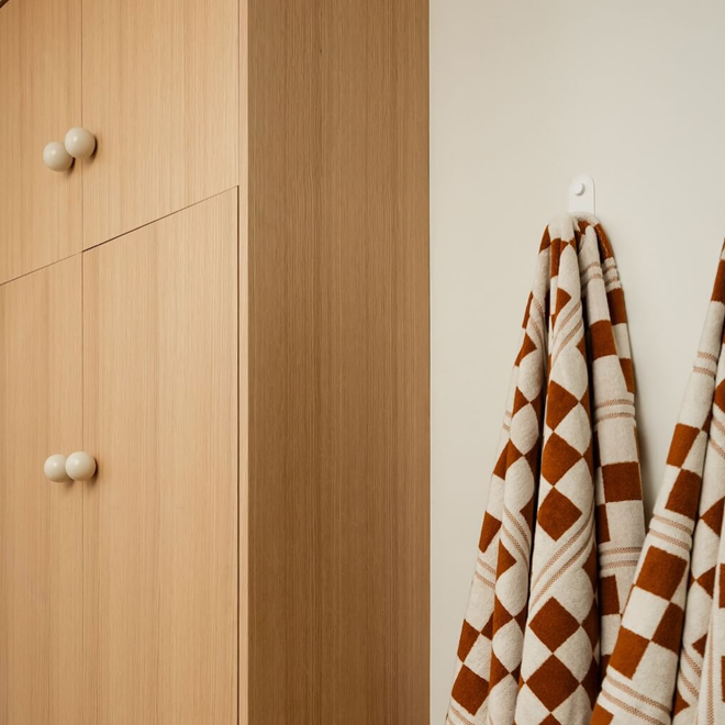 Wooden wardrobe with patterned towels hanging on a hook