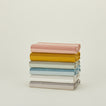 Stack of folded Essential Striped Tabecloths in various colors.