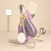 Simple metal kitchen tools in silver with net and eggplant on warm background.