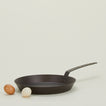 spun iron frying pan with eggs