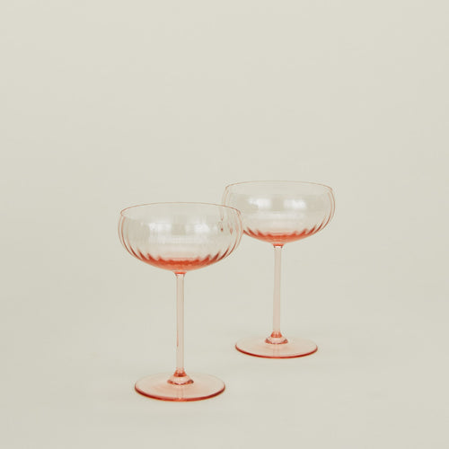 Set of two ribbed blush coupe glasses.