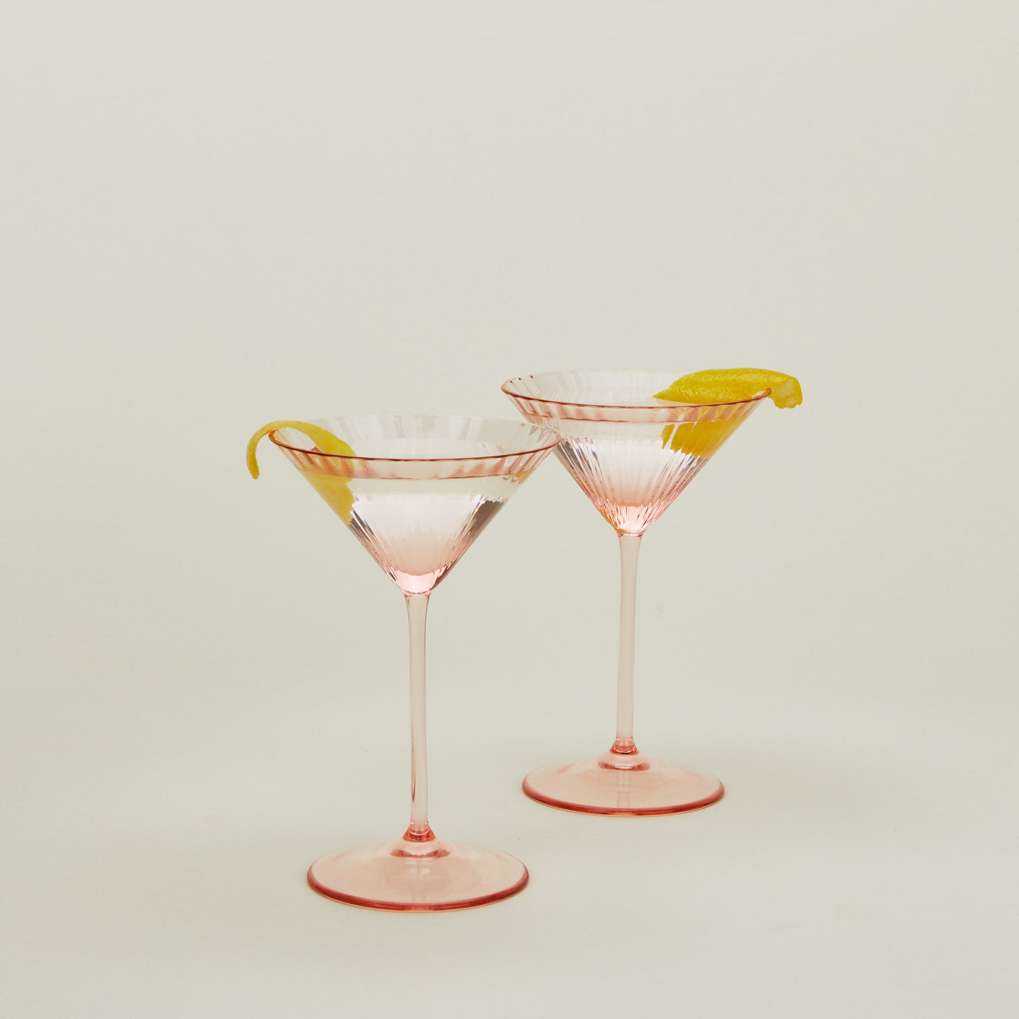 Set of two ribbed blush martini glasses with cocktail.