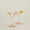 Set of two ribbed blush martini glasses with cocktail.
