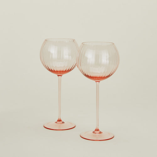 Set of two ribbed blush wine glasses.