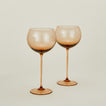 Set of two ribbed brown wine glasses.