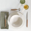 Placesetting with Atelier Dinner Plate on ivory tablecloth.