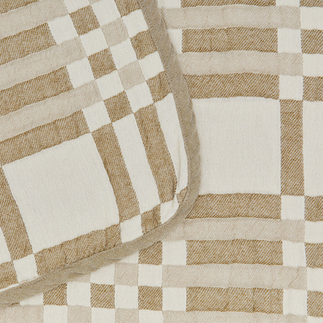 Close-up of a checkered blanket with brown and ivory squares.