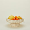 Natural rattan pedestal bowl with citrus fruits