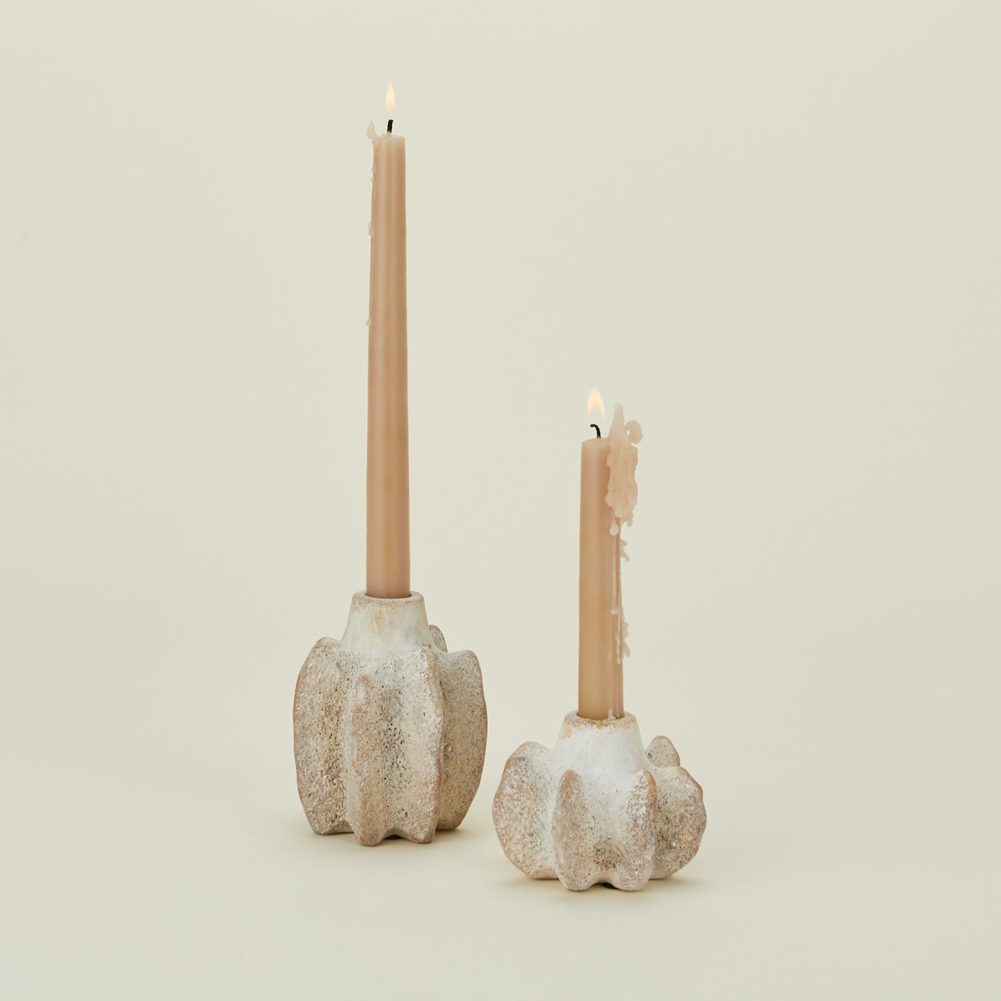 Brutalist candle holders with lit tapers