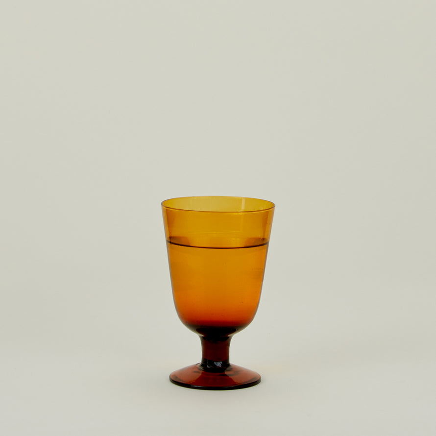 Stemmed Wine Glass in Amber, filled with water.