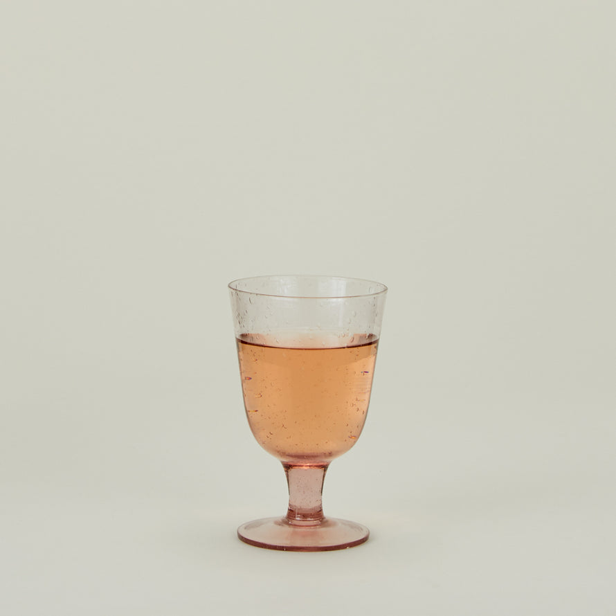 Stemmed Wine Glass in Blush, filled with water.