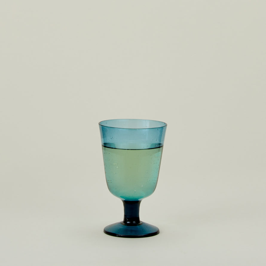Stemmed Wine Glass in Peacock, filled with water.