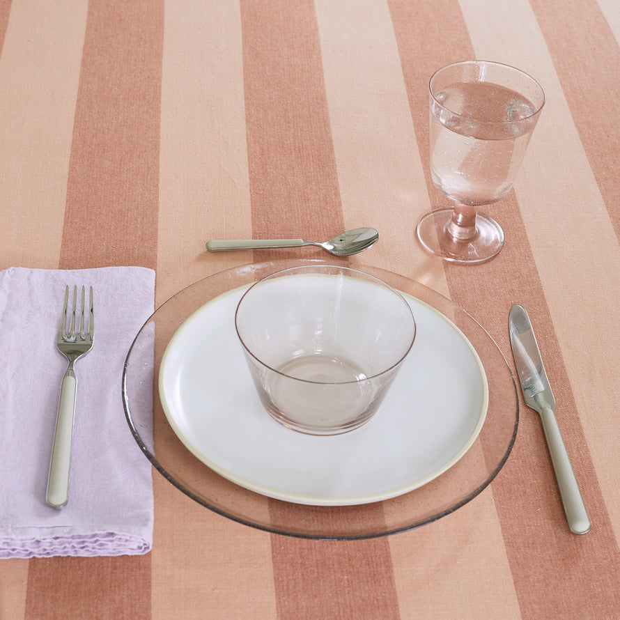 Placesetting with Stemmed Wine Glass in Blush on pink striped tablecloth.