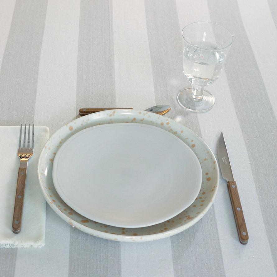 Placesetting with Stemmed Wine Glass in Clear on ivory striped tablecloth.