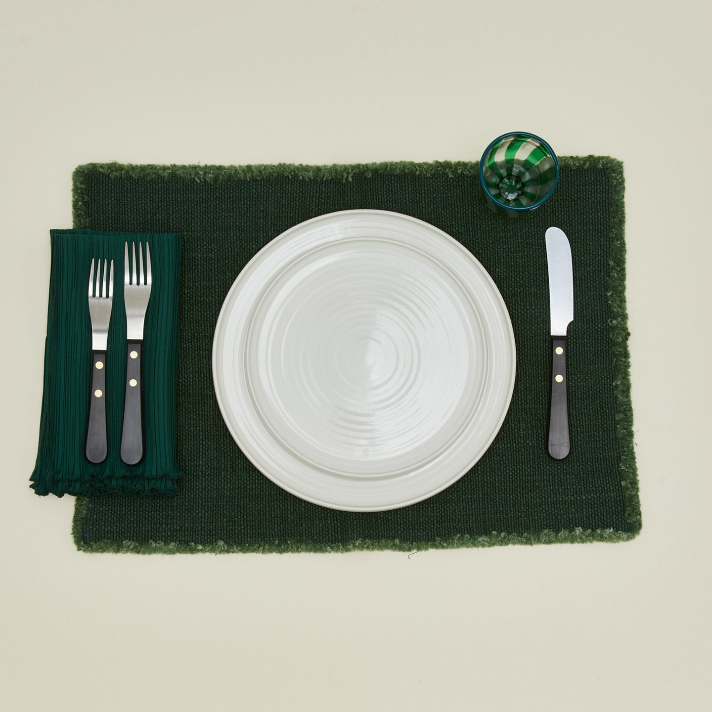 Cahaya pleated napkin in olive with place setting and placemat