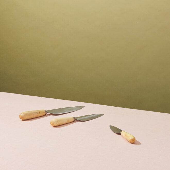 Pallares knives, set of 3, laying on a pink surface. 