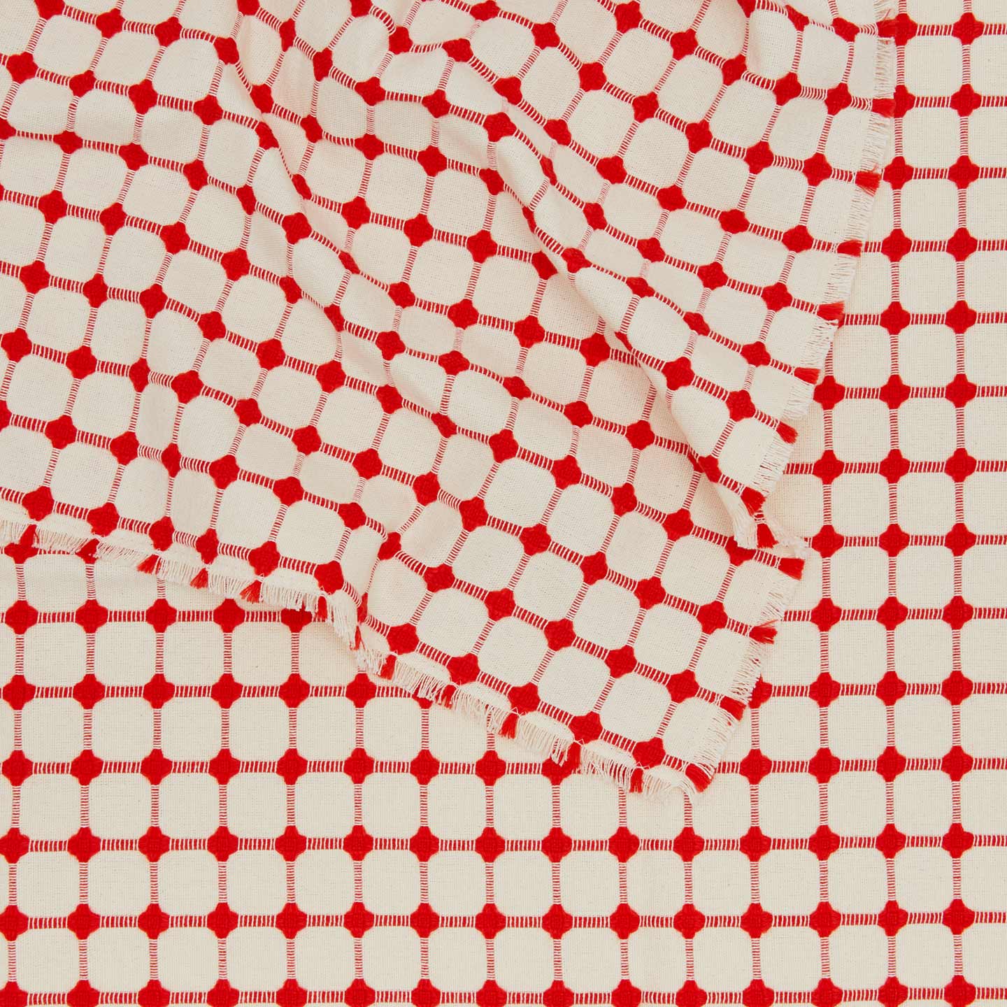 Close up view of Dove and Donkey wicker fringed tablecloth in cherry