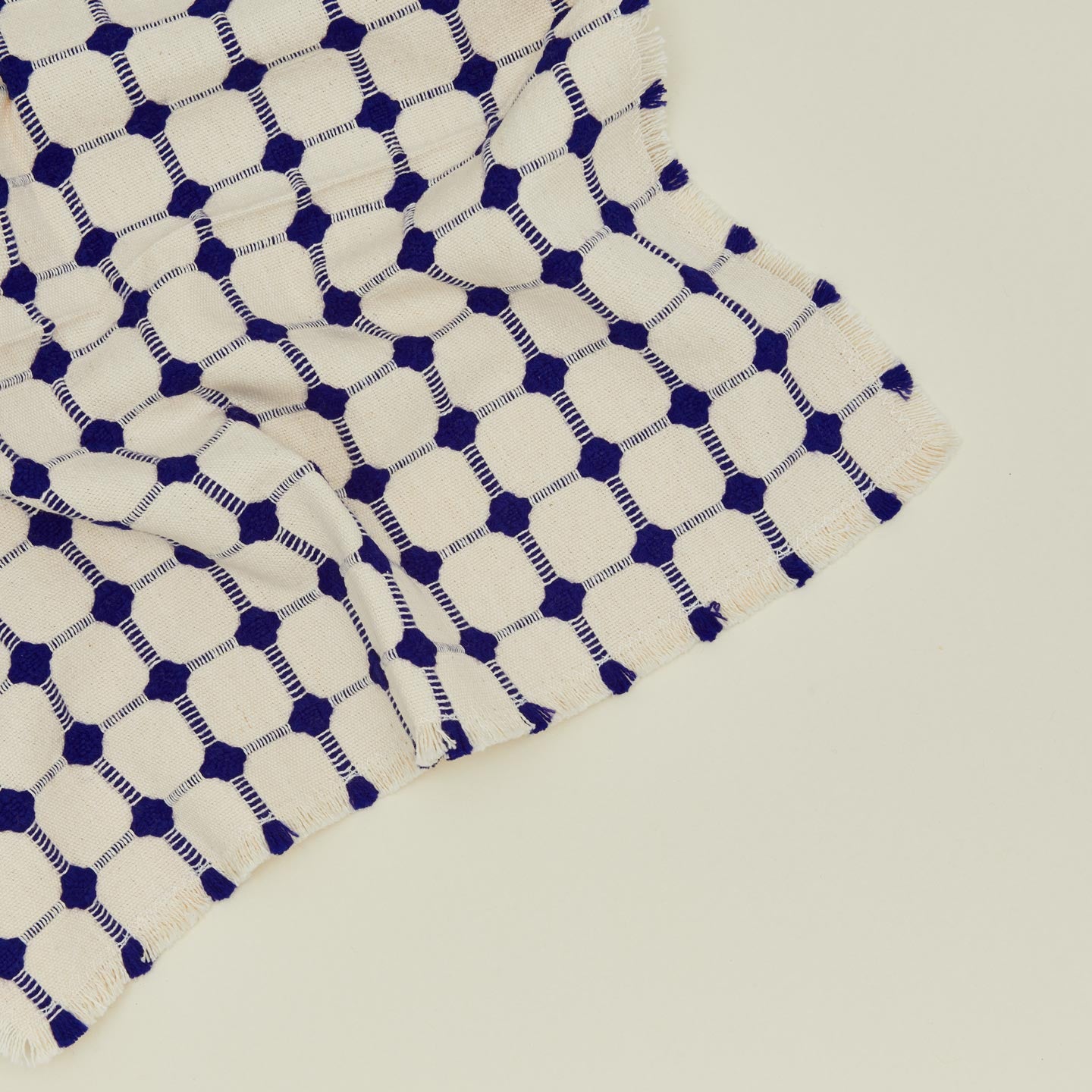 Close up view of Dove and Donkey wicker fringed napkin in cobalt