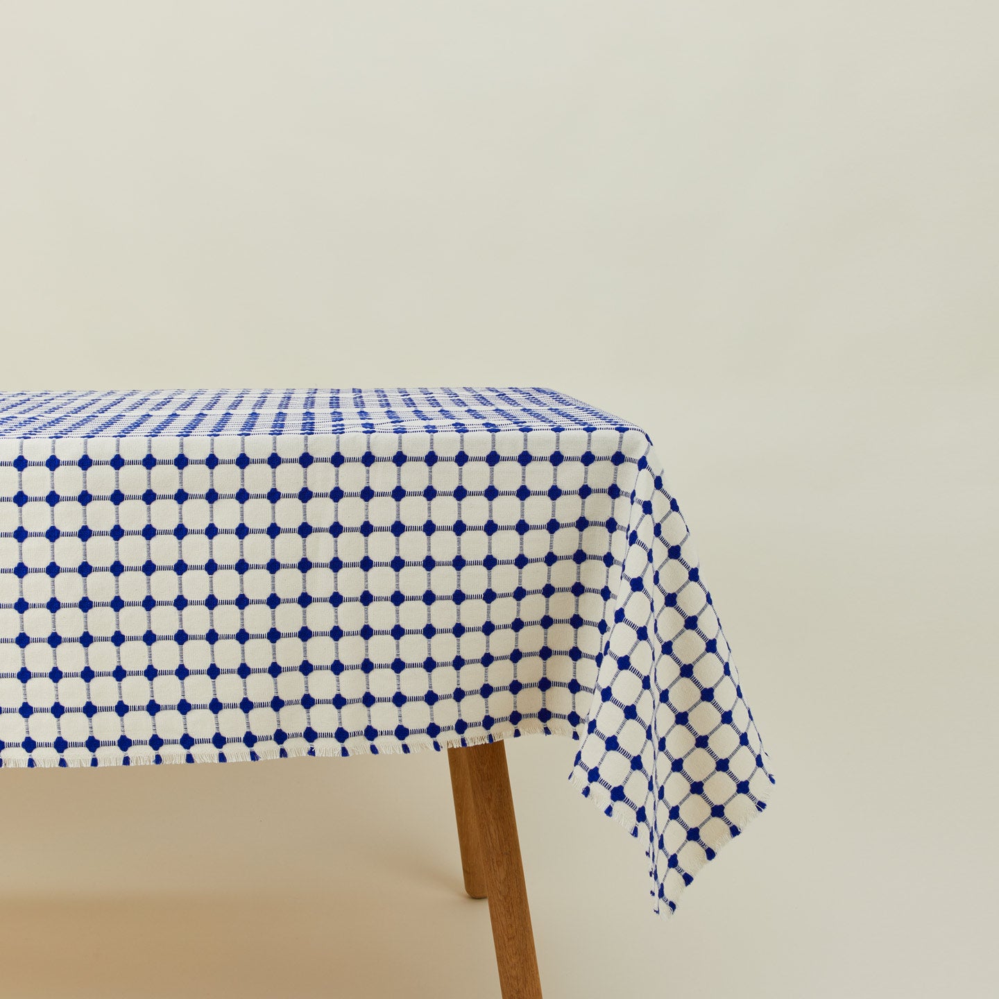 Dove and Donkey wicker fringed tablecloth in cobalt on table