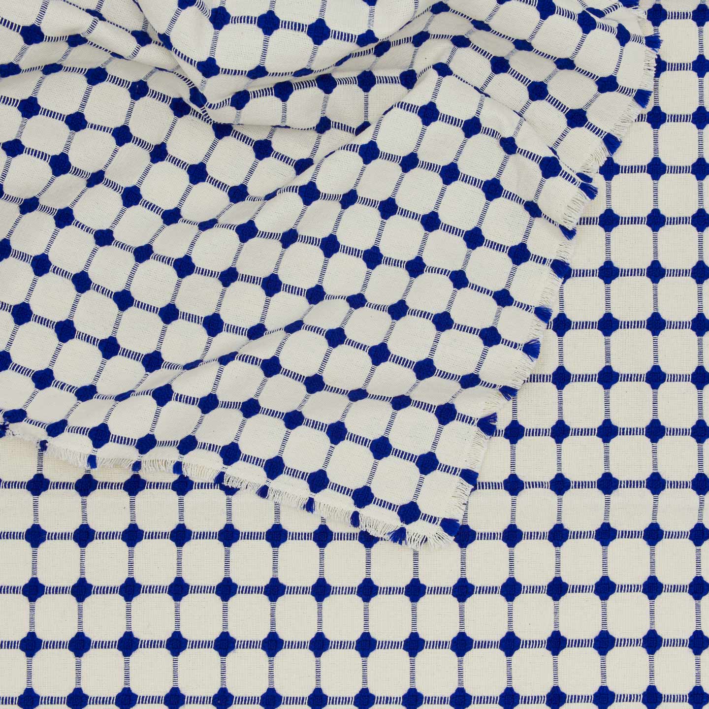 Close up view of Dove and Donkey wicker fringed tablecloth in cobalt