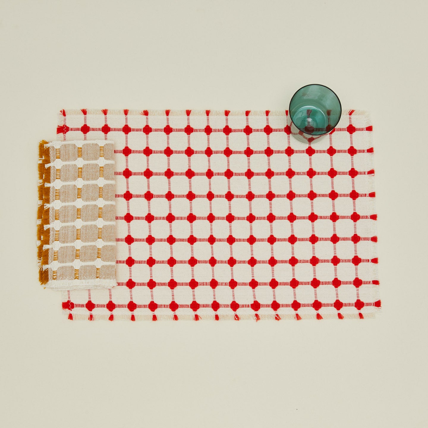Dove and Donkey Hopsack Fringed Napkin  in honey with Wicker placemat and peacock essential glass