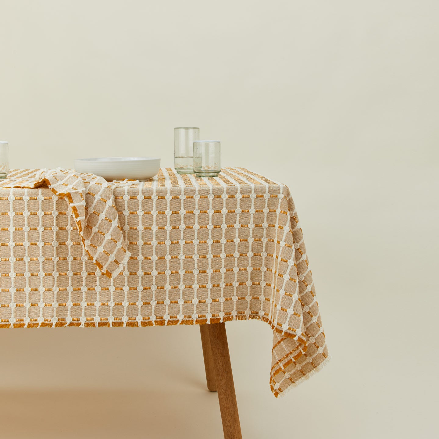 Dove and Donkey hopsack tablecloth in honey on table with place setting