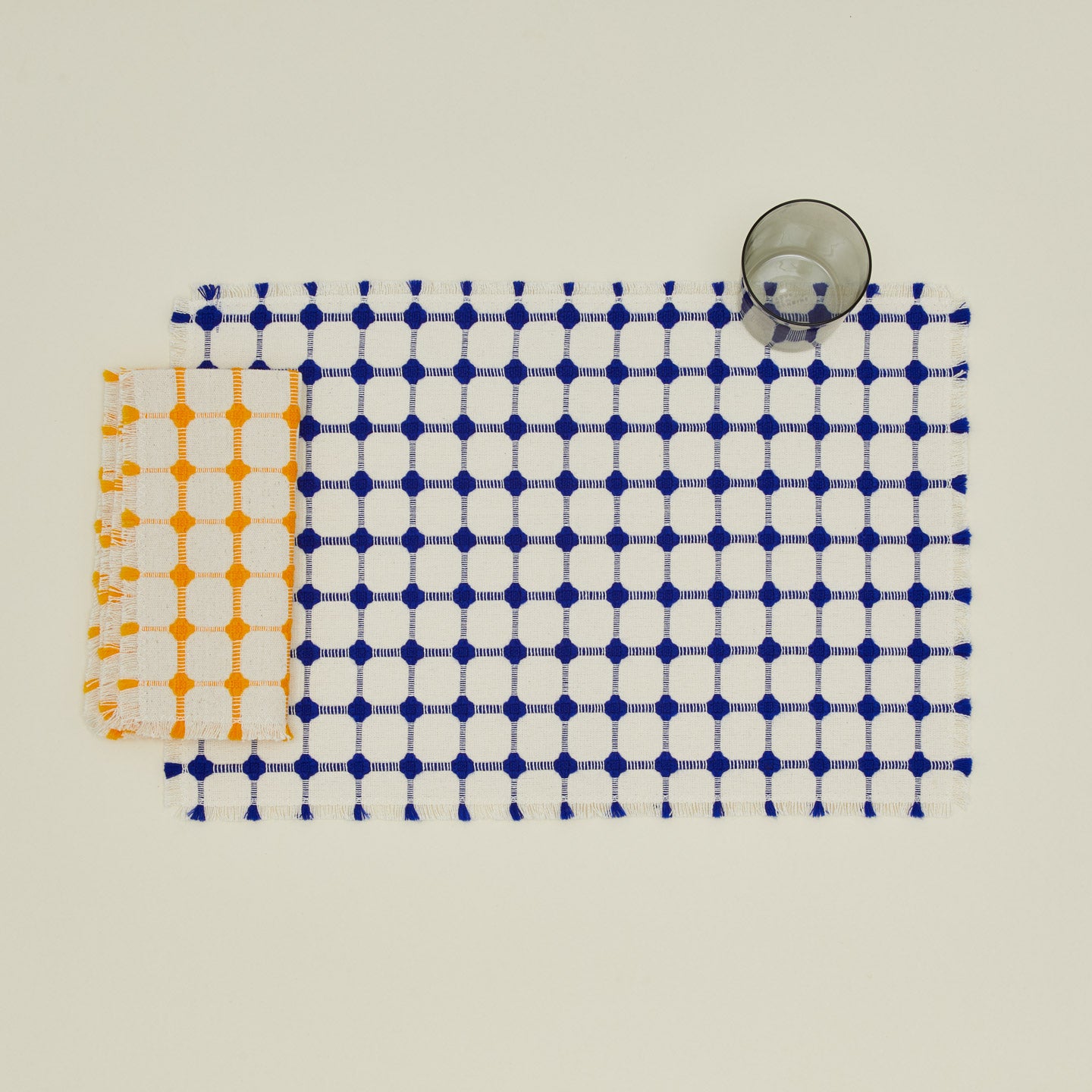Dove and Donkey Wicker Fringed Napkin  in marigold with Wicker placemat and grey essential glass