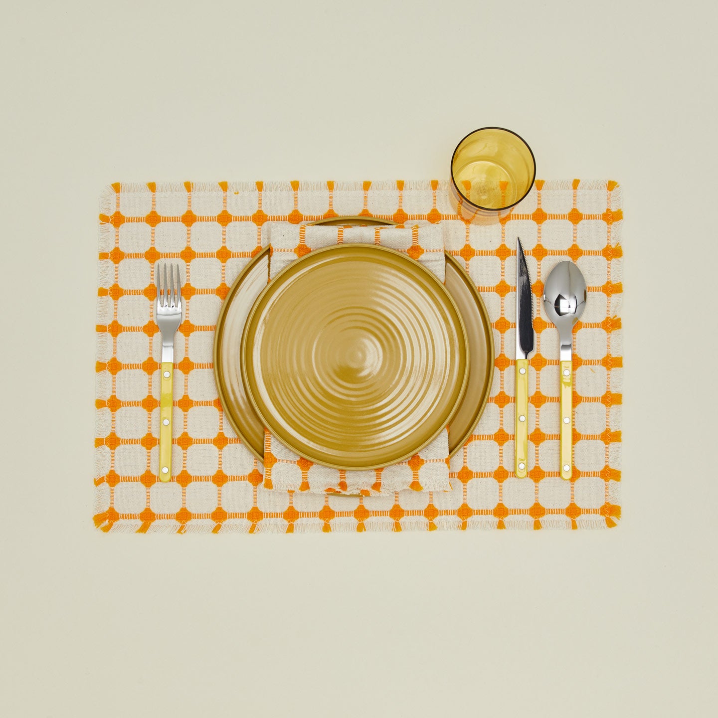 Dove and Donkey wicker fringed placemat in marigold with place setting