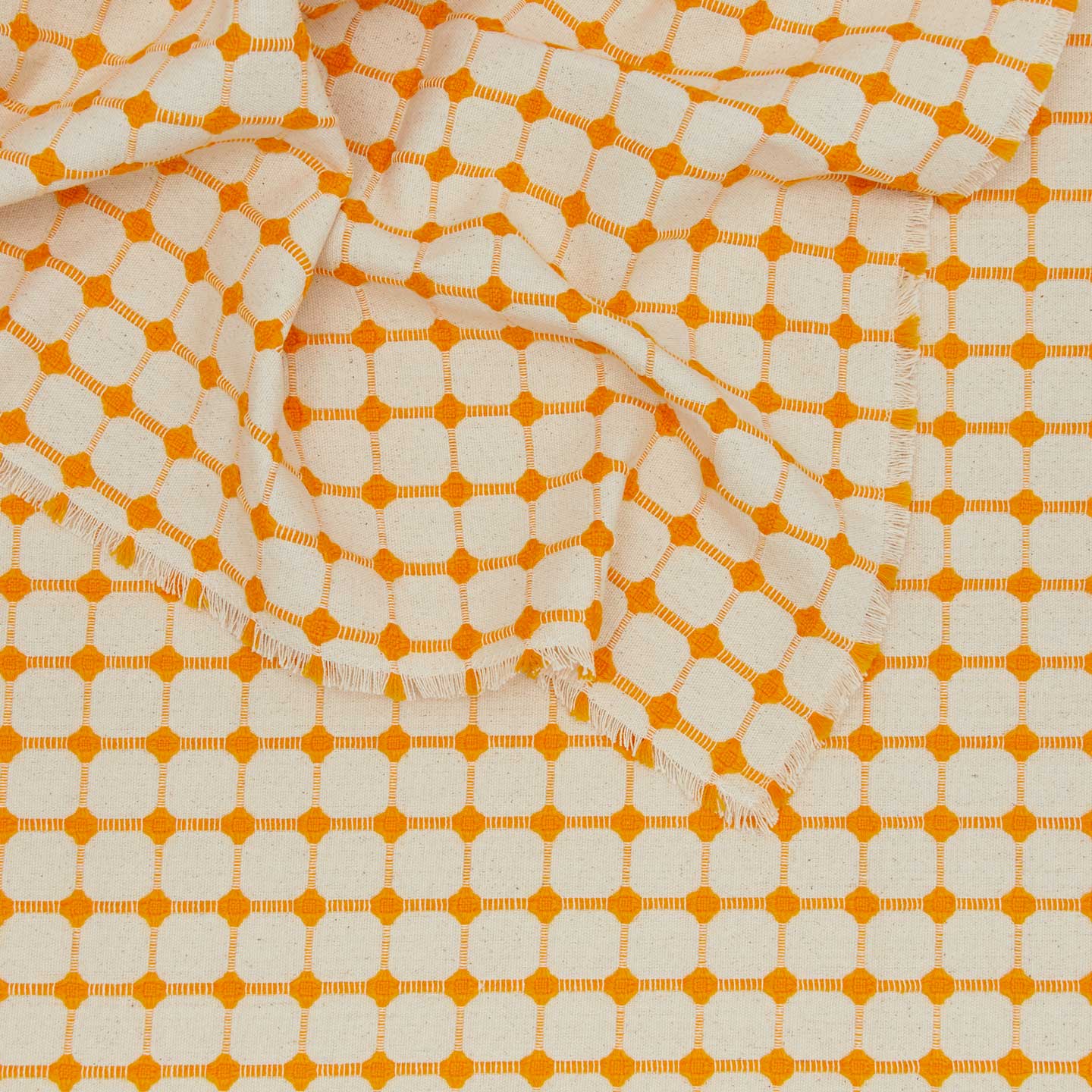 Close up view of Dove and Donkey wicker fringed tablecloth in marigold