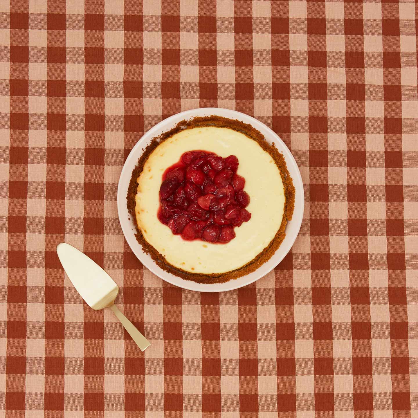 Essential pie dish with cheesecake on gingham background