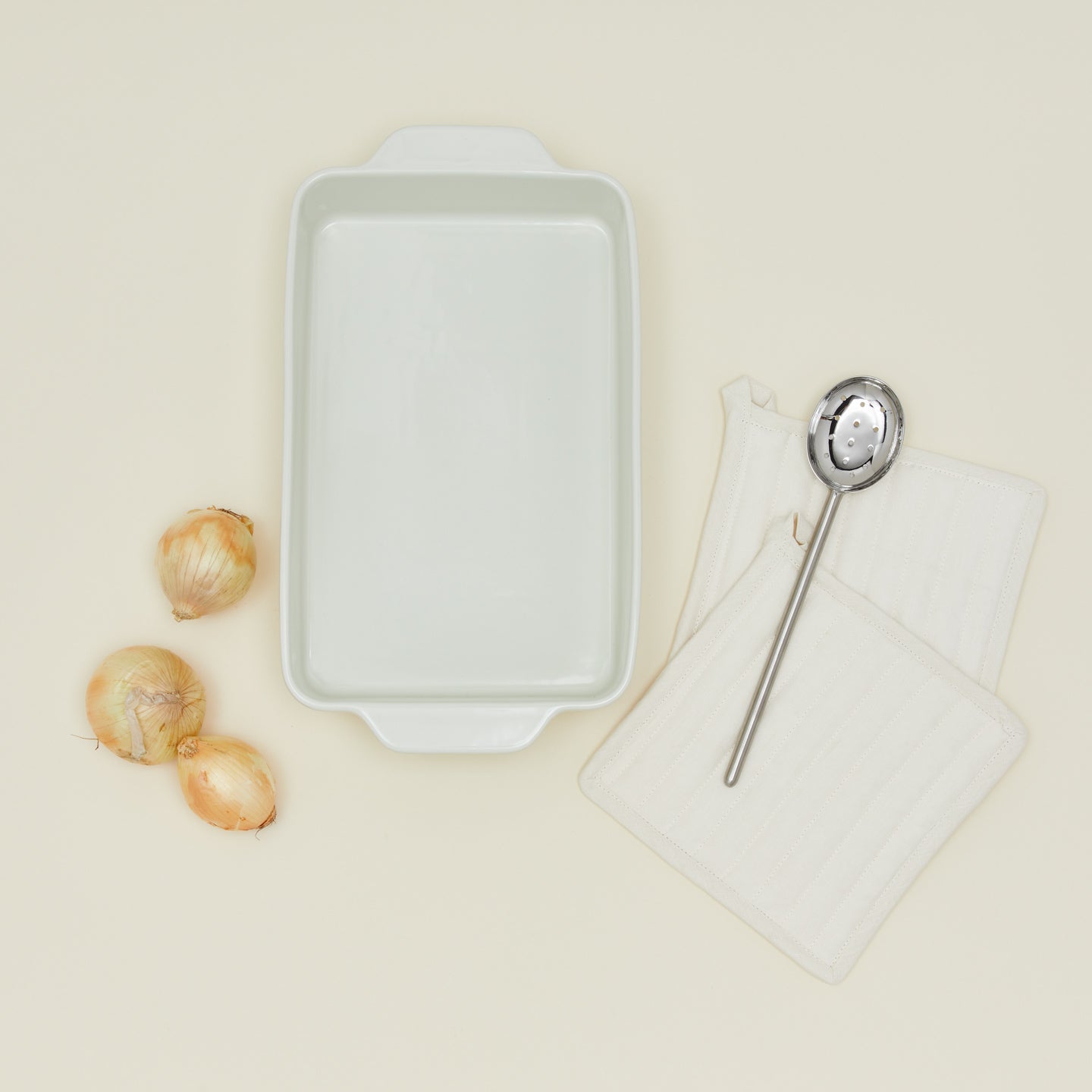 9" x 13" essential bakeware in bone with onions, spoon, and oven mits
