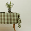 Essential Gingham tablecloth in sage/olive on a table with florals.