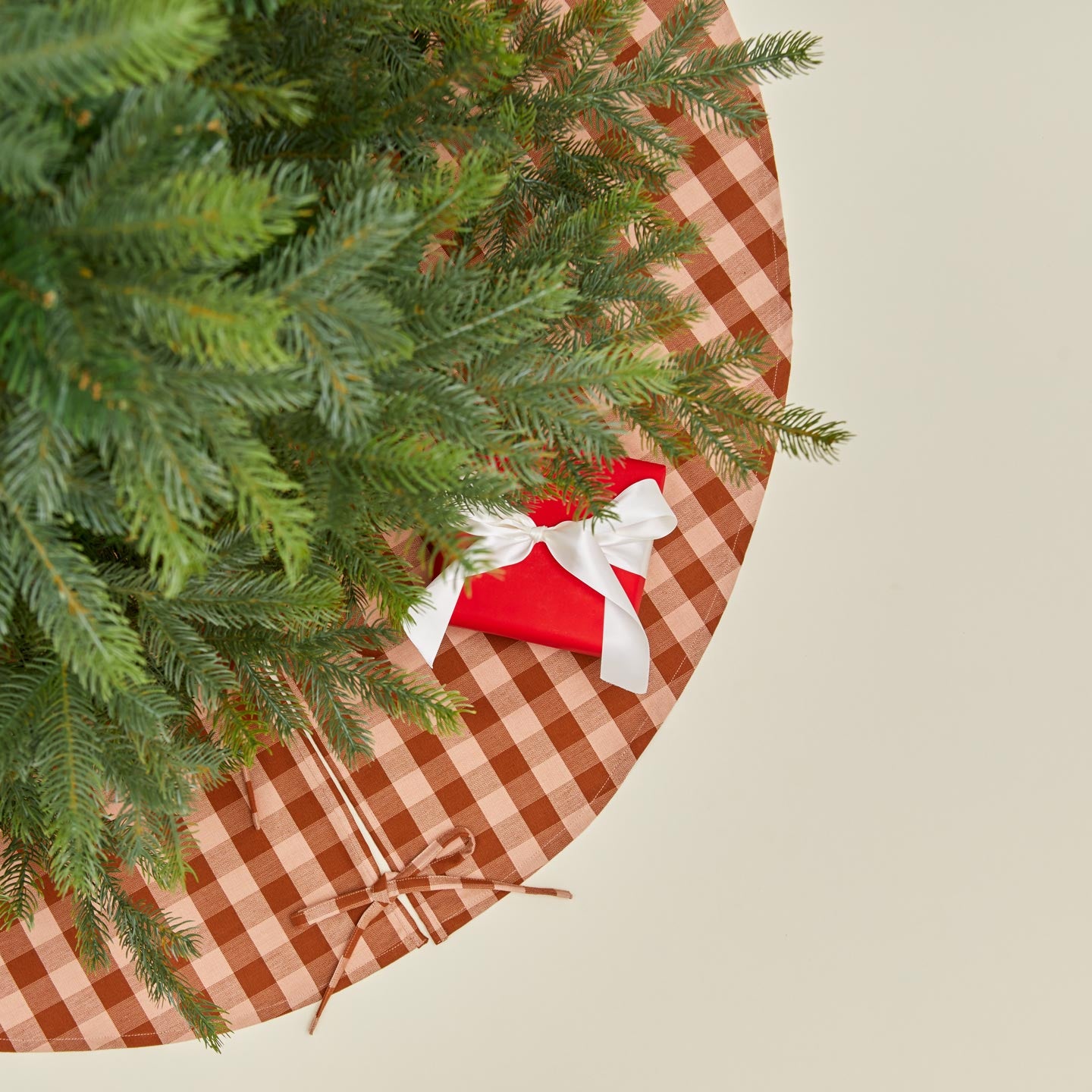 Overhead view of Essential GIngham Tree Skirt - Blush/Terracotta with tree