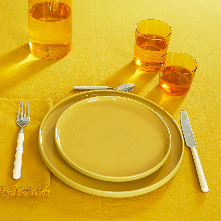 Placesetting with Essential Glassware in Amber on yellow tablecloth.